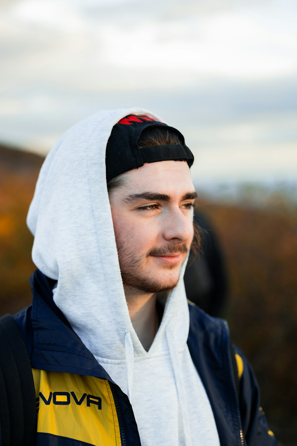 a man wearing a hoodie and looking off into the distance