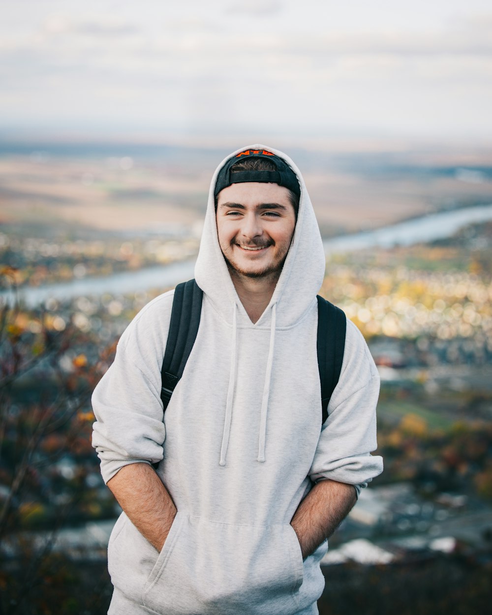 a man in a hoodie standing with his arms crossed