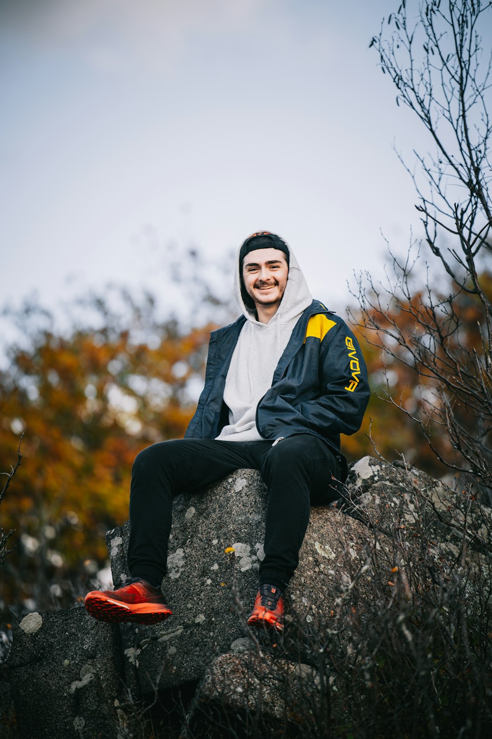 a man sitting on top of a large rock