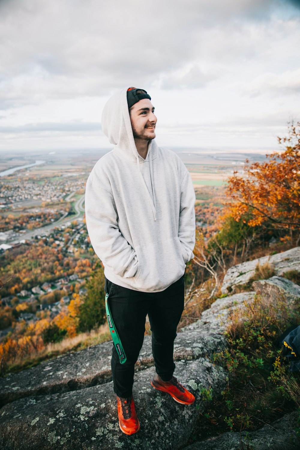 a man in a hoodie standing on top of a mountain
