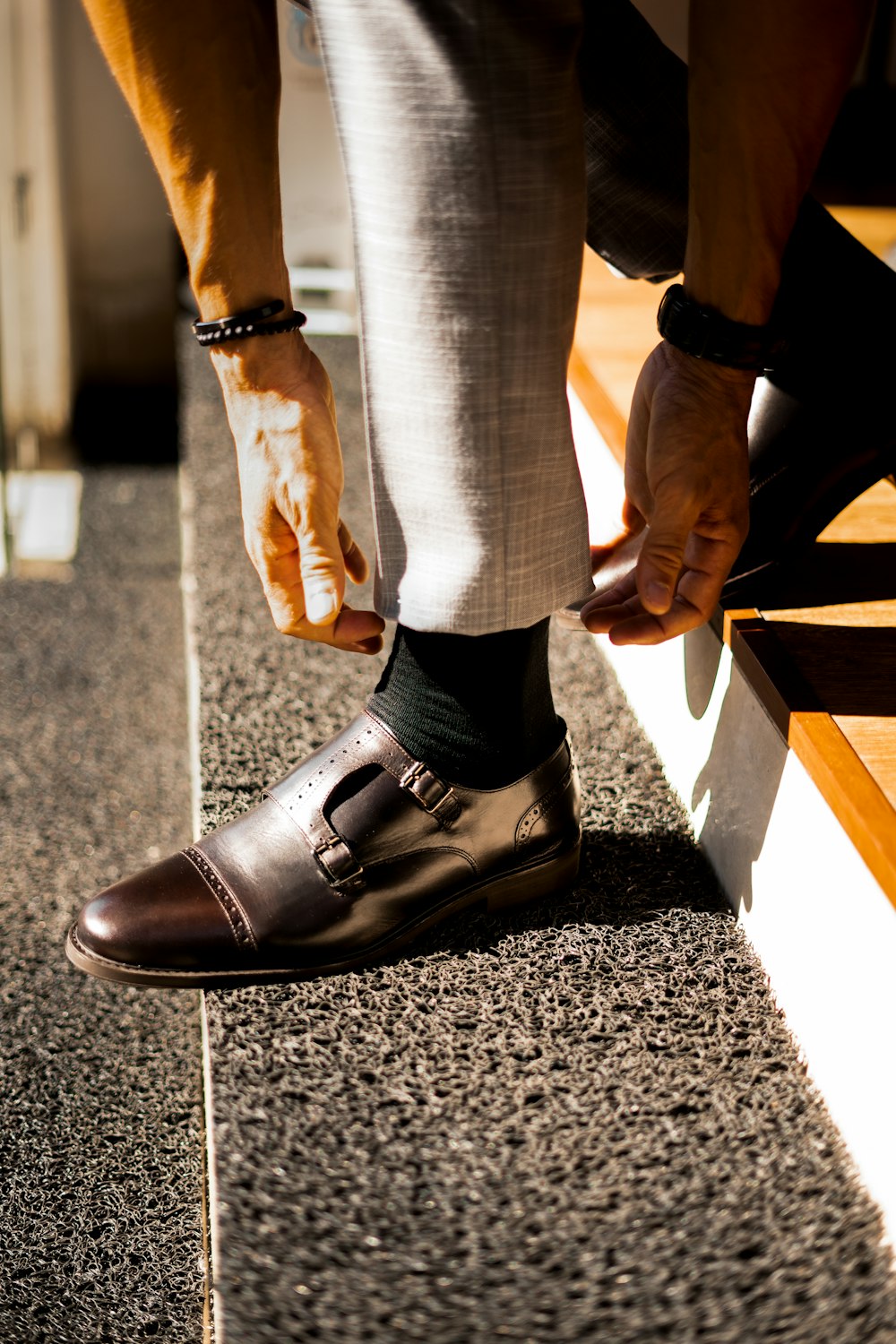 a man is tying his shoes on a bench