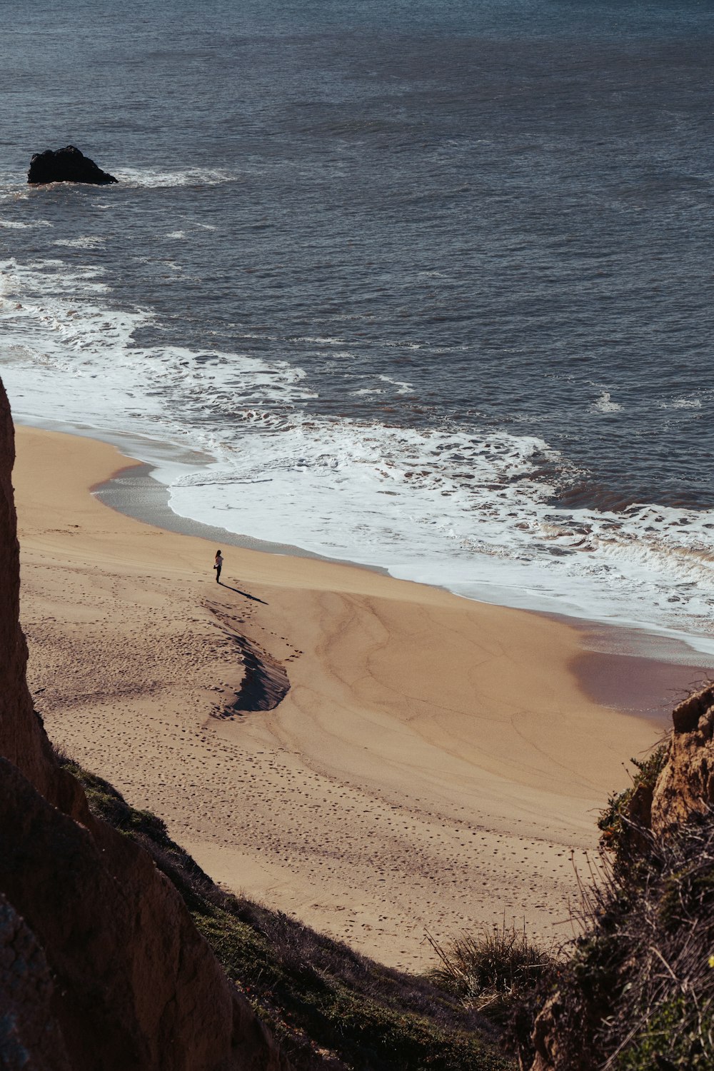 a person standing on a beach next to the ocean