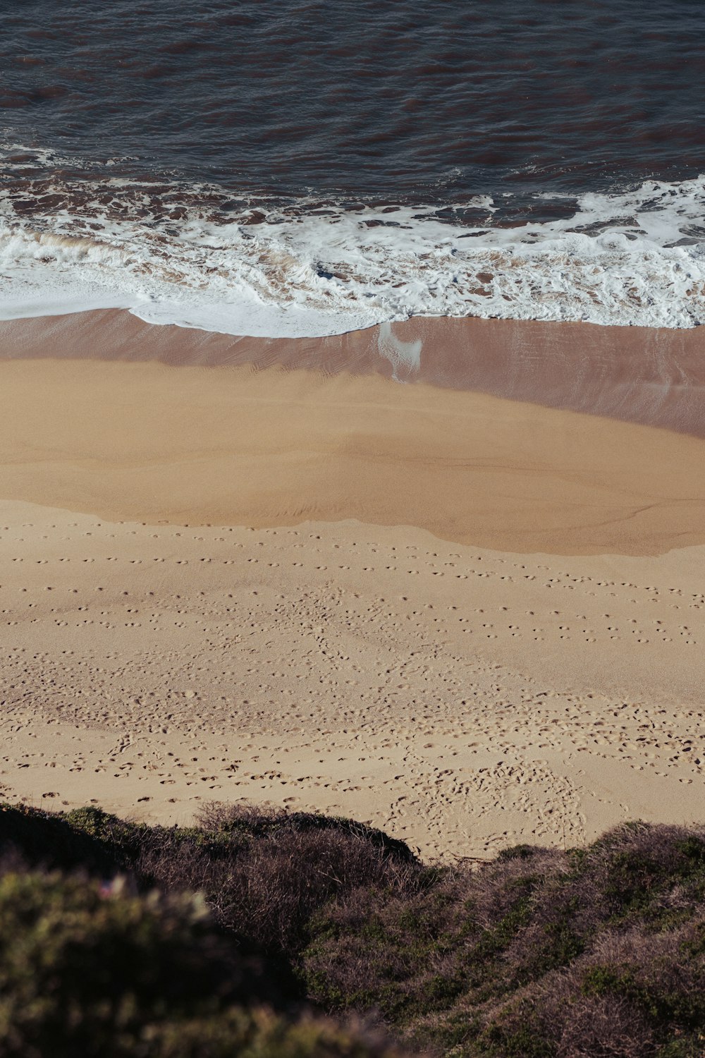 a sandy beach with waves coming in to shore