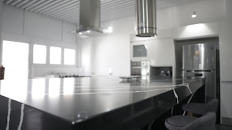 a kitchen with a large counter top and chairs