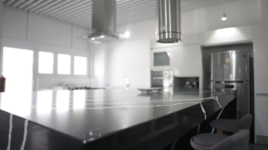 a kitchen with a large counter top and chairs