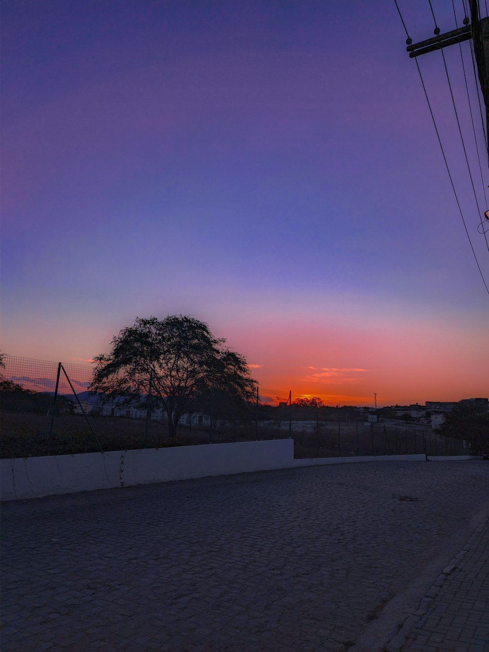 the sun is setting over a city street