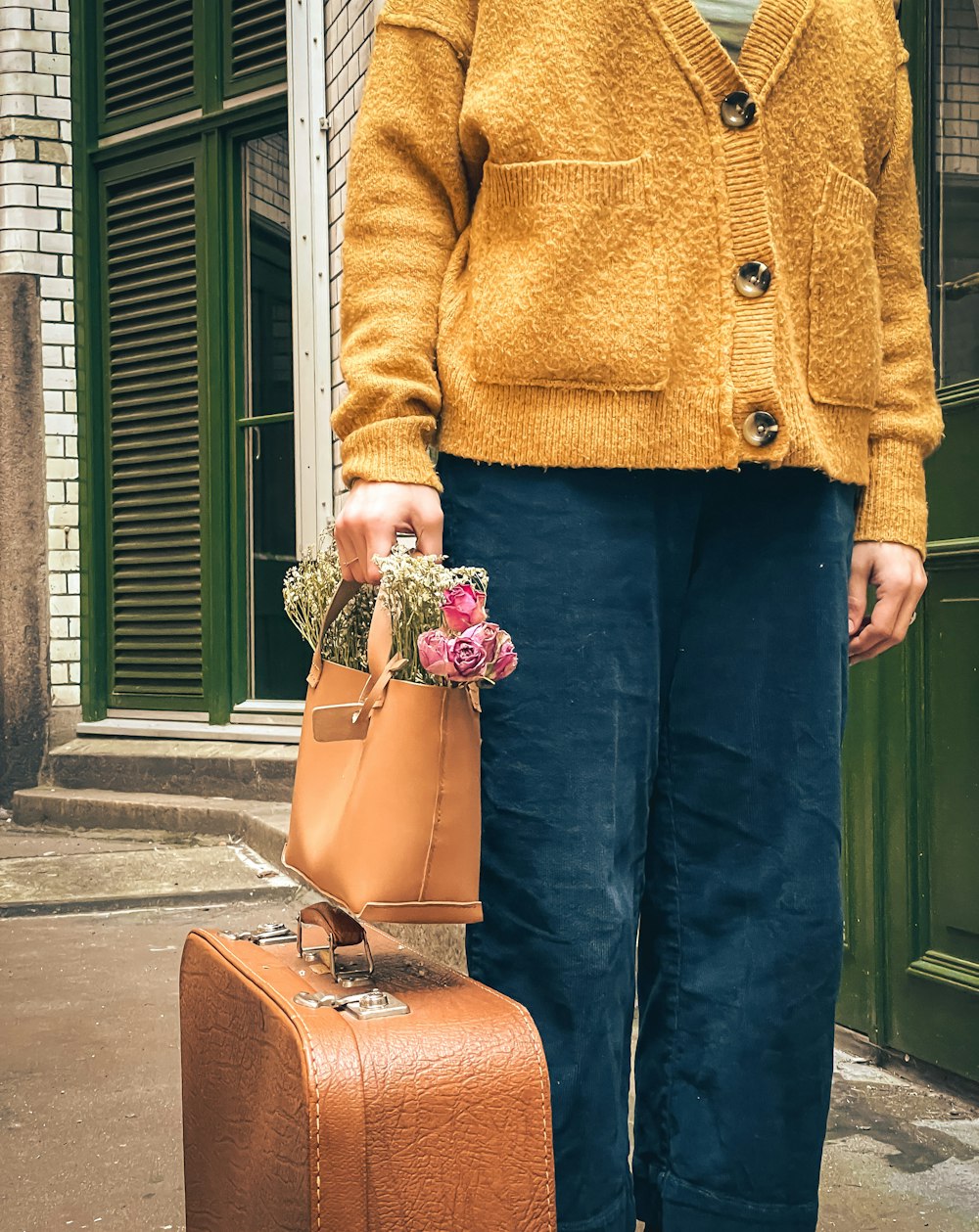 a woman standing next to a brown suitcase