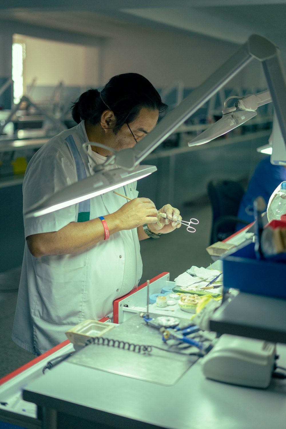 a woman in a white lab coat holding a pair of scissors