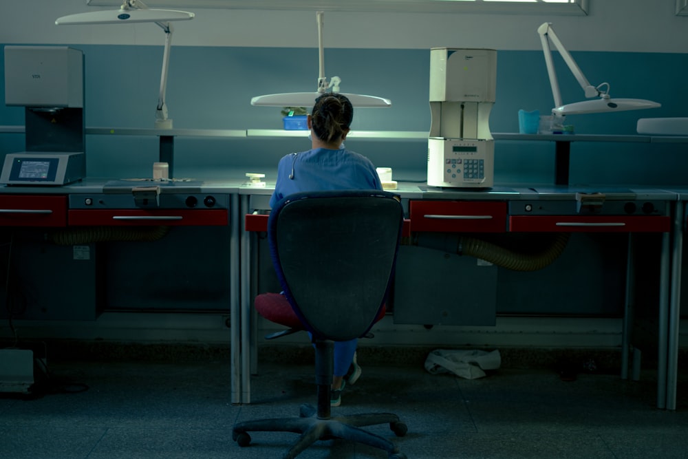 a woman sitting at a desk in a room
