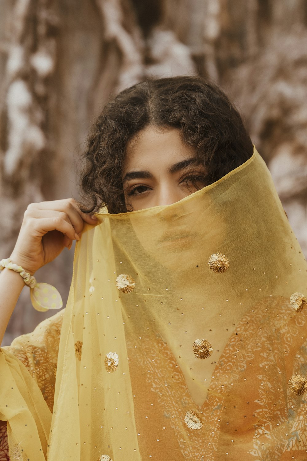 a woman with a yellow veil covering her face