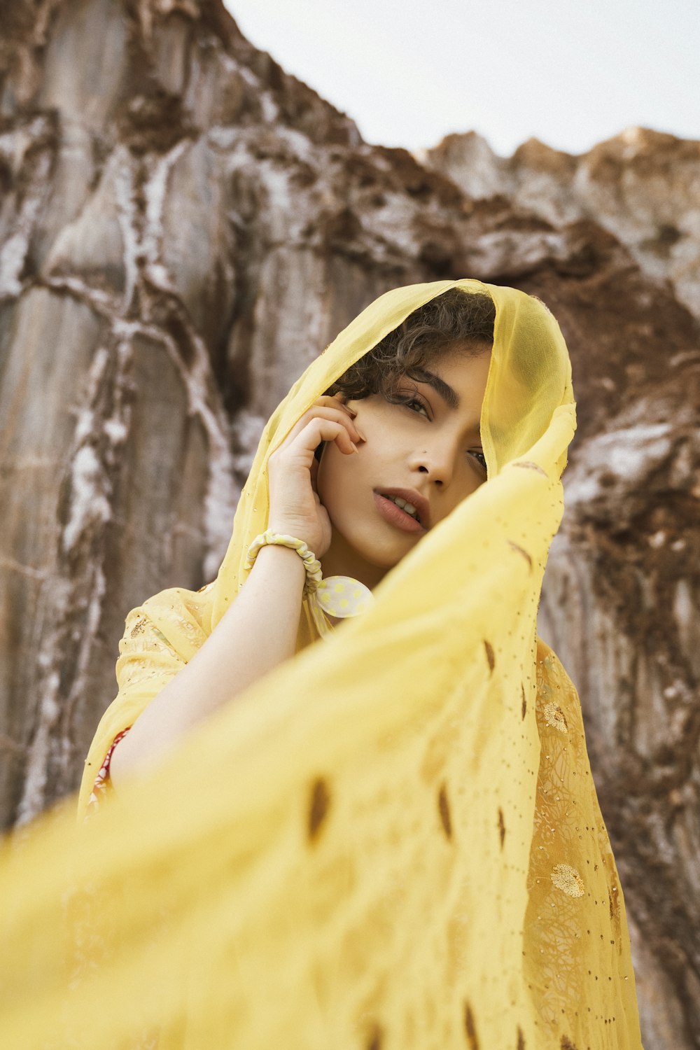 a woman wearing a yellow shawl is posing for a picture
