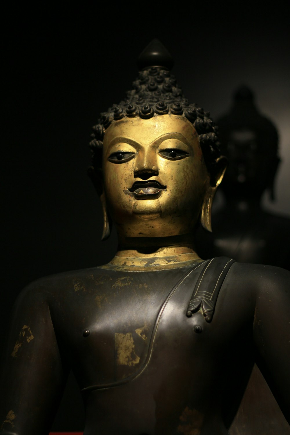 Une statue de Bouddha dorée dans une pièce sombre
