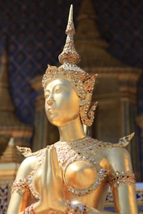 a golden statue of a woman with a crown on her head
