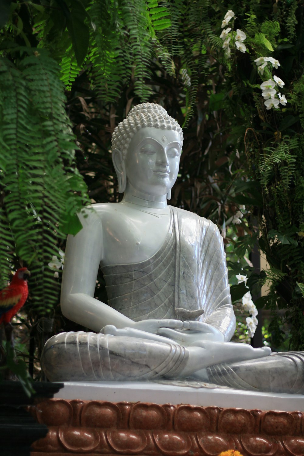 Une statue d’un Bouddha assis dans un jardin