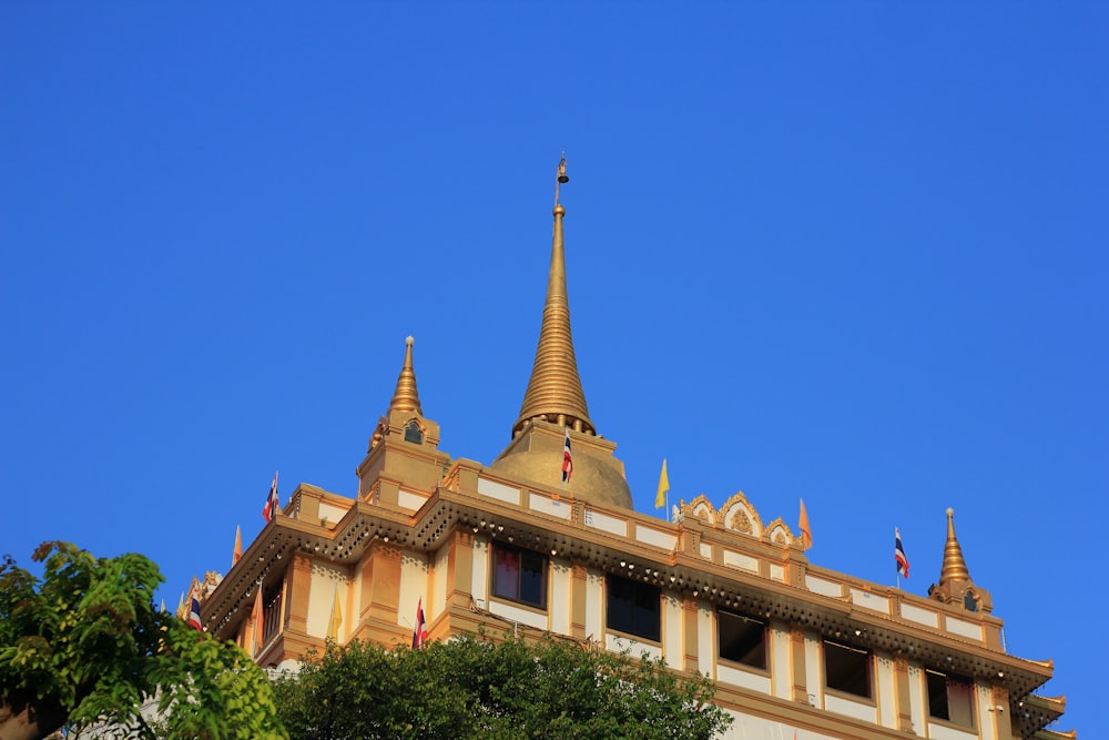 ein hohes Gebäude mit einer goldenen Spitze darauf