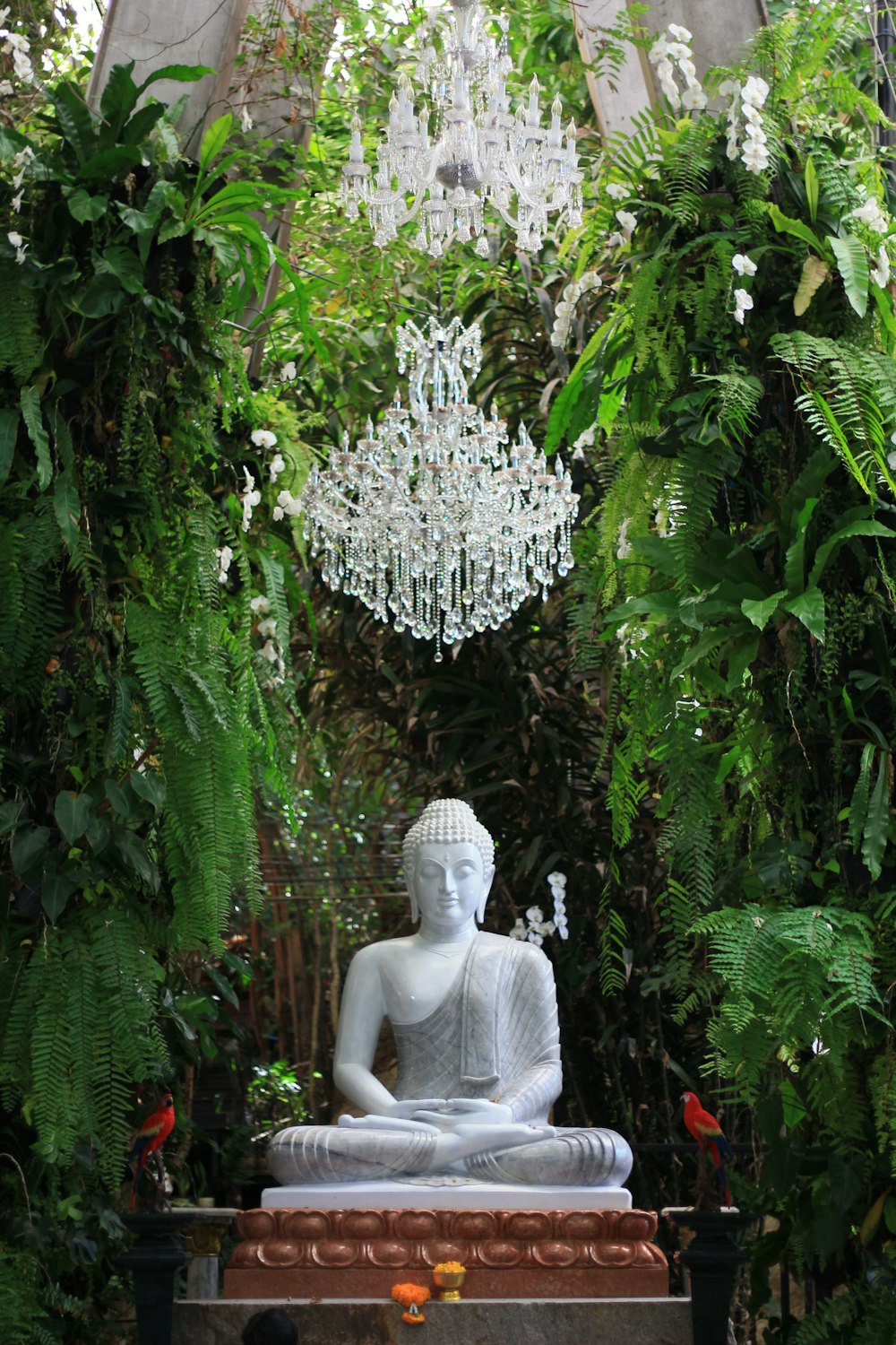 Eine Buddha-Statue in einem Garten, umgeben von viel Grün