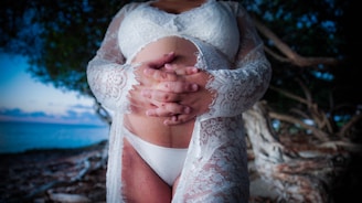 a woman in a white bodysuit holding her hands together