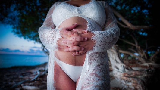 a woman in a white bodysuit holding her hands together