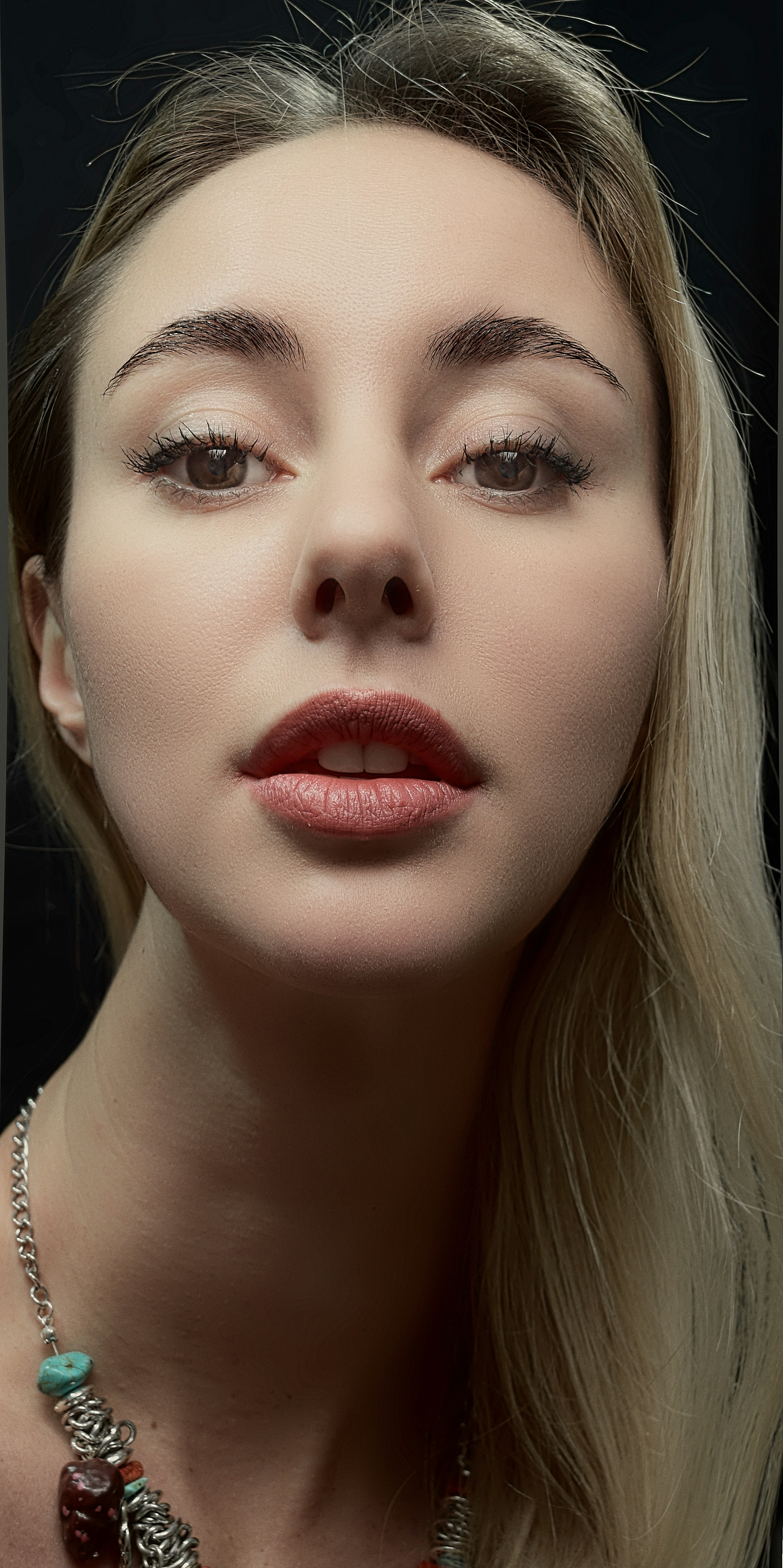 a woman with long blonde hair wearing a necklace