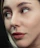 a close up of a woman's face with a black background