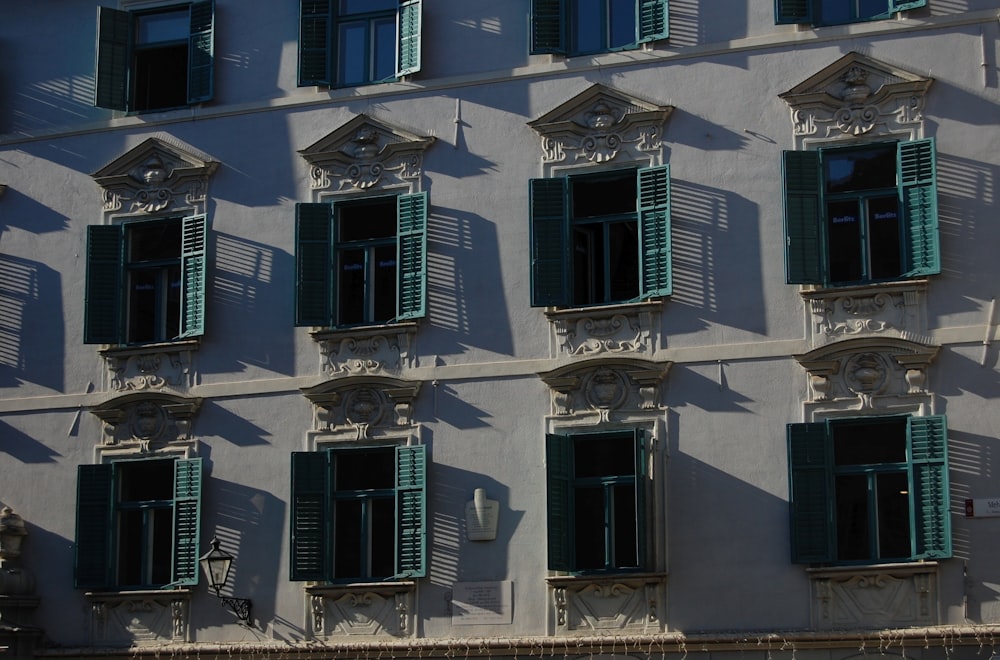 a building with many windows and green shutters