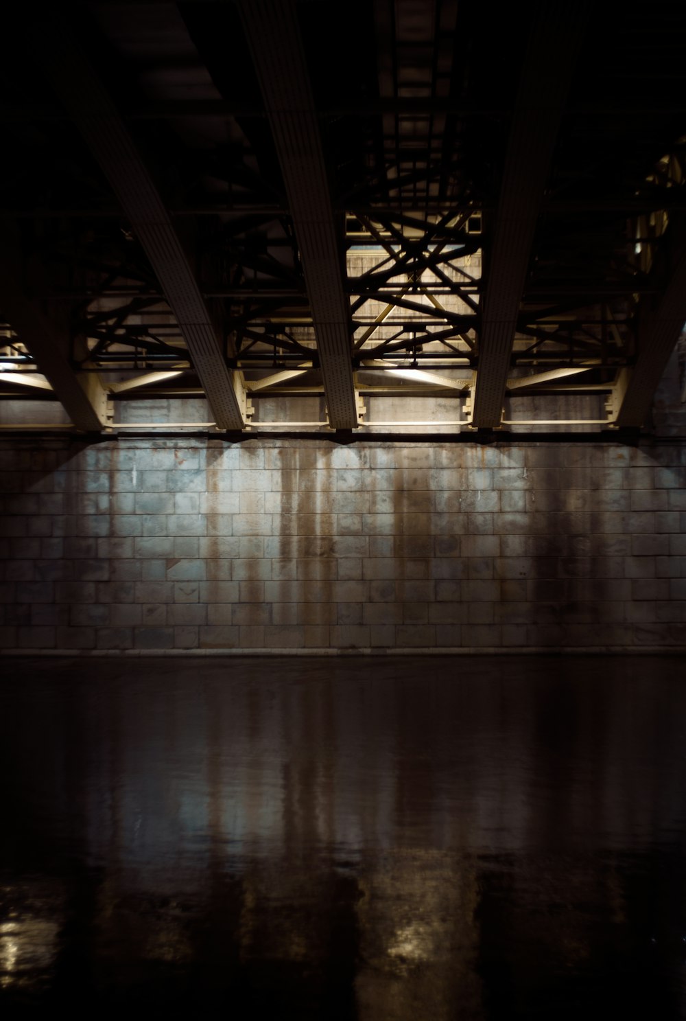 a dark room with a brick wall and water