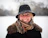 a woman wearing a hat and scarf in the snow