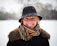 a woman wearing a hat and scarf in the snow