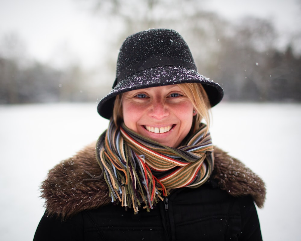 a woman wearing a hat and scarf in the snow