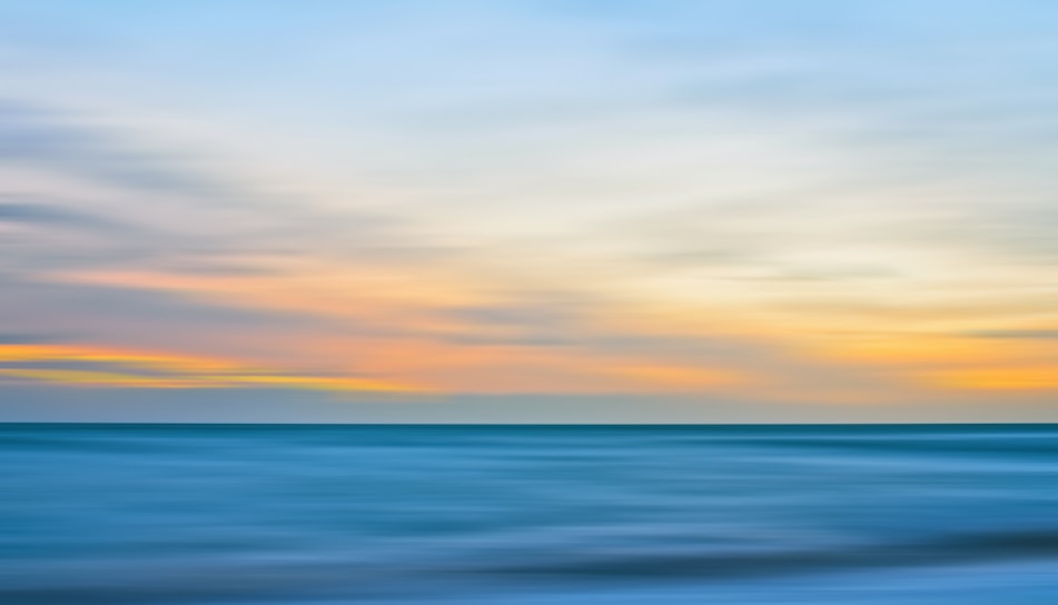 A serene seascape painting capturing the gentle ebb of ocean waves under a soft pastel sky.