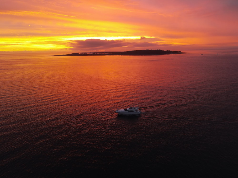 a small boat floating on top of a large body of water