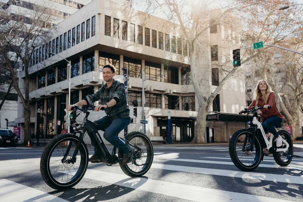 a man and a woman riding bikes on a city street