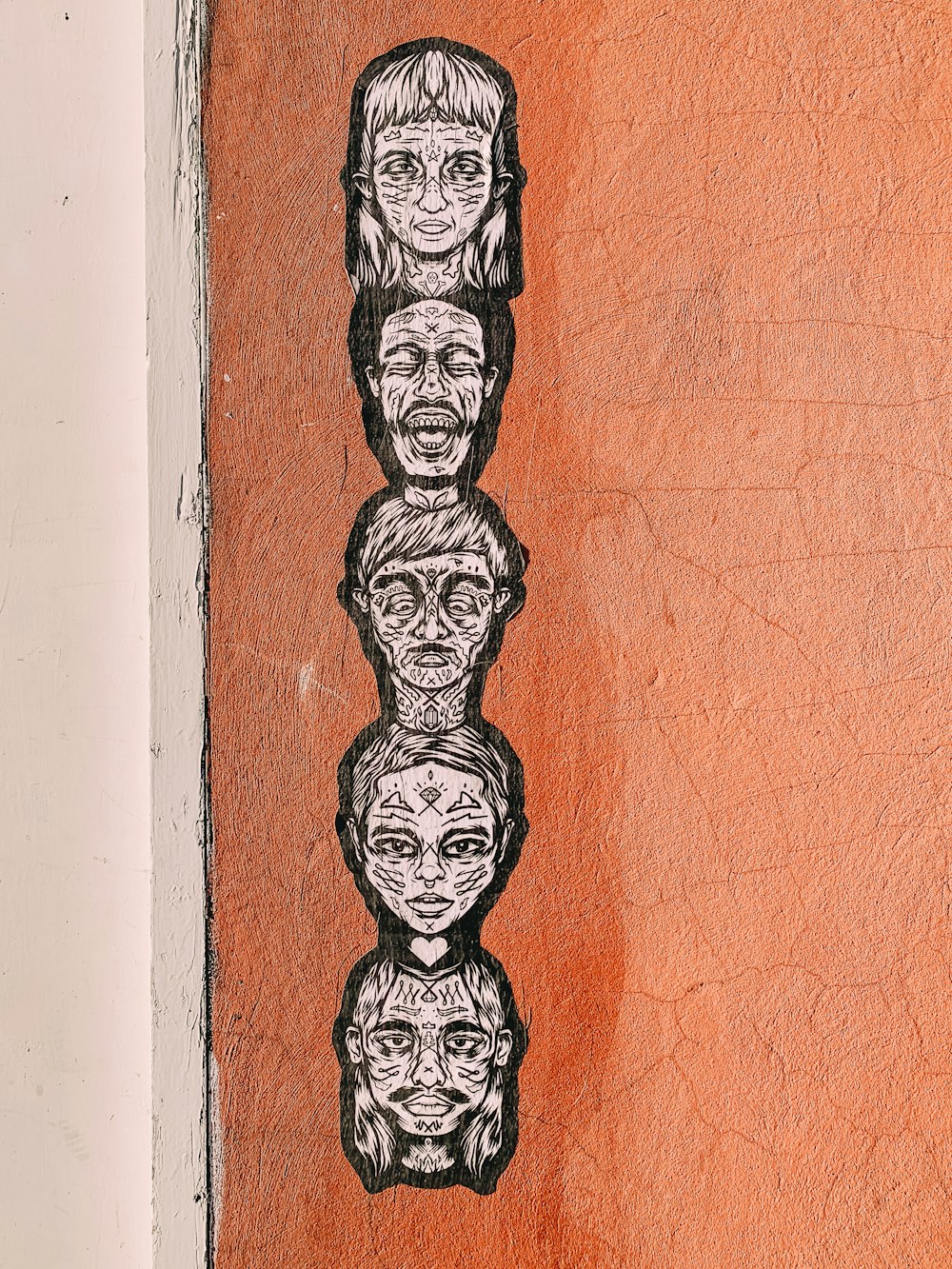 a drawing of a group of faces on a wall