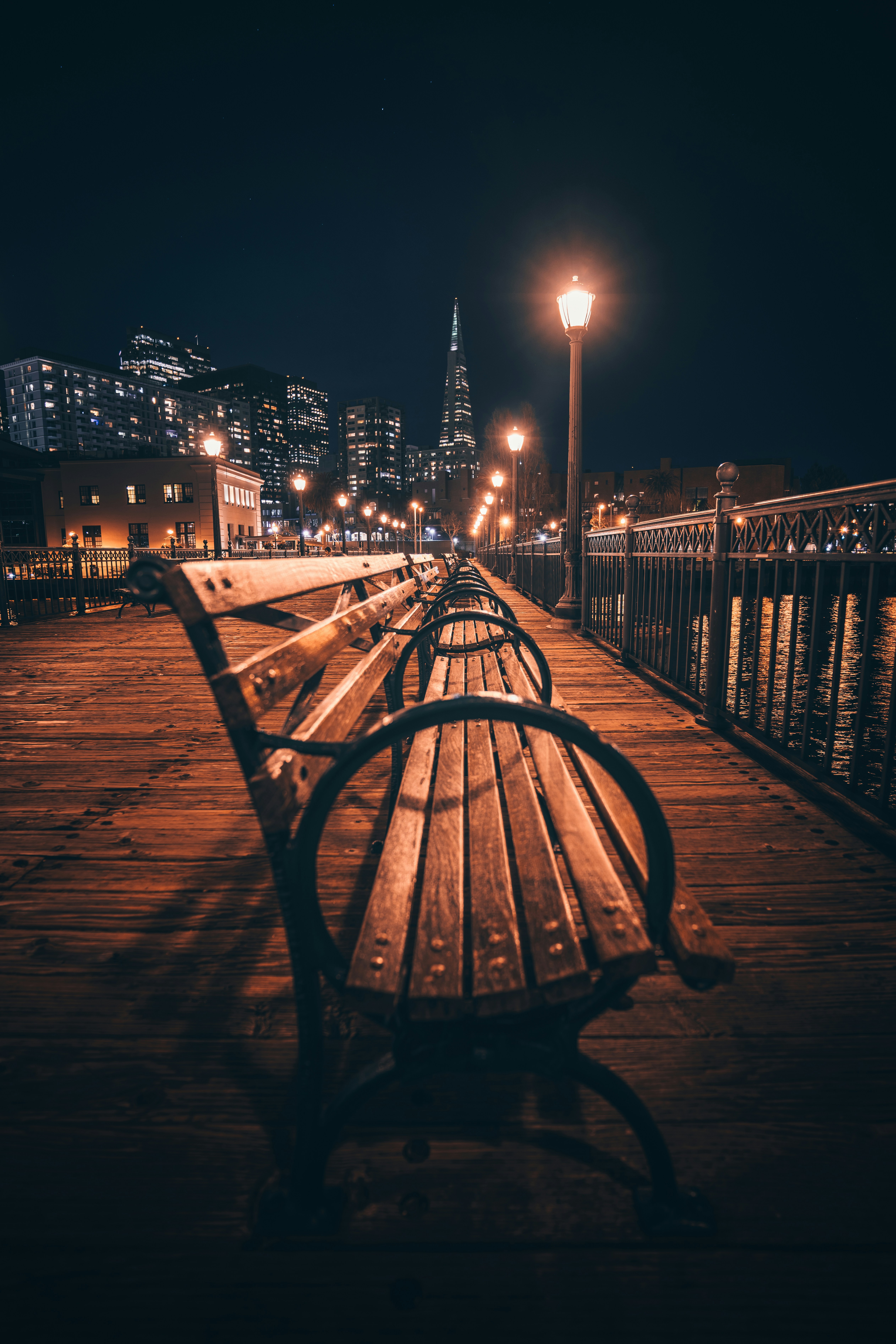 a row of benches sitting on top of a wooden pier