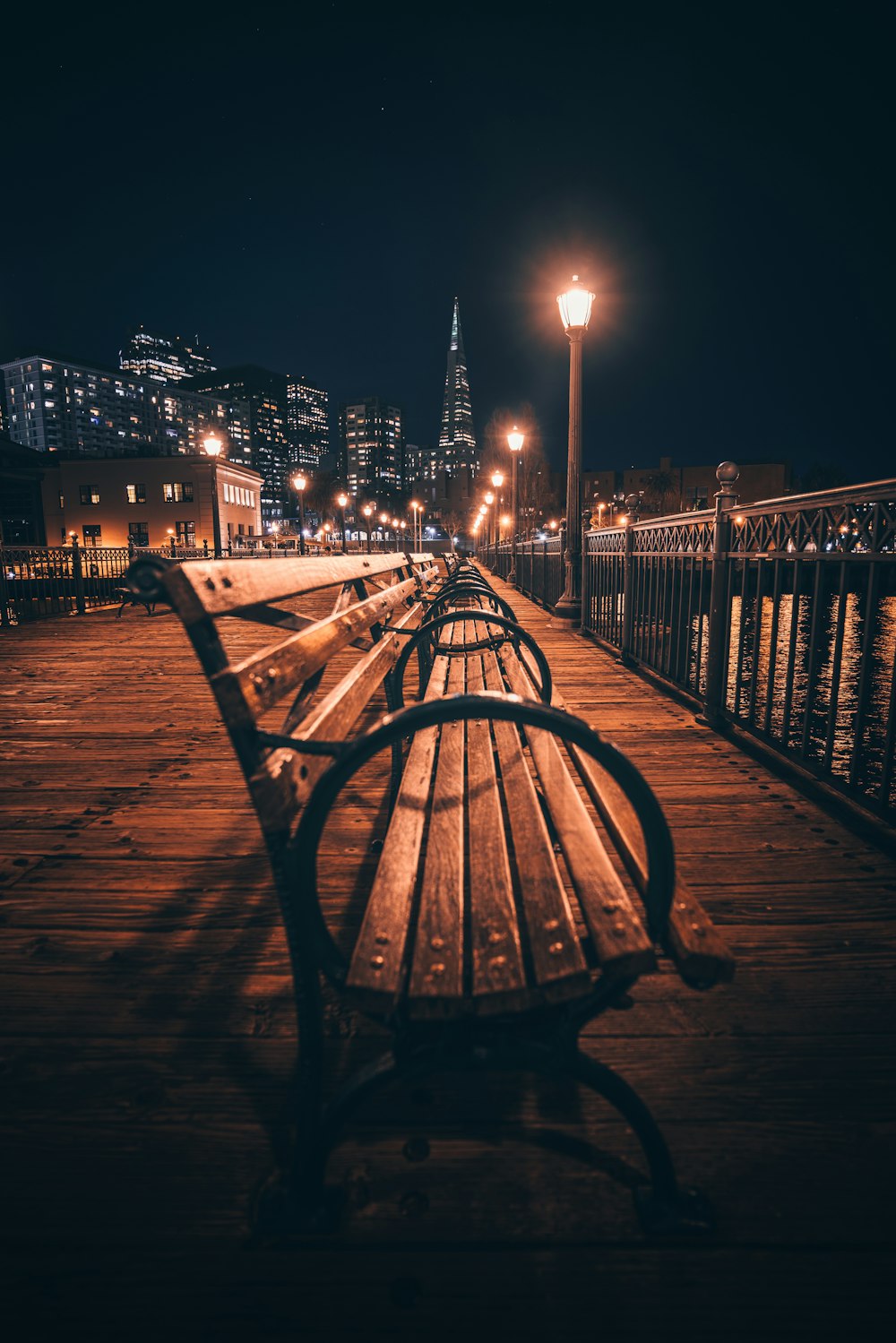 a row of benches sitting on top of a wooden pier