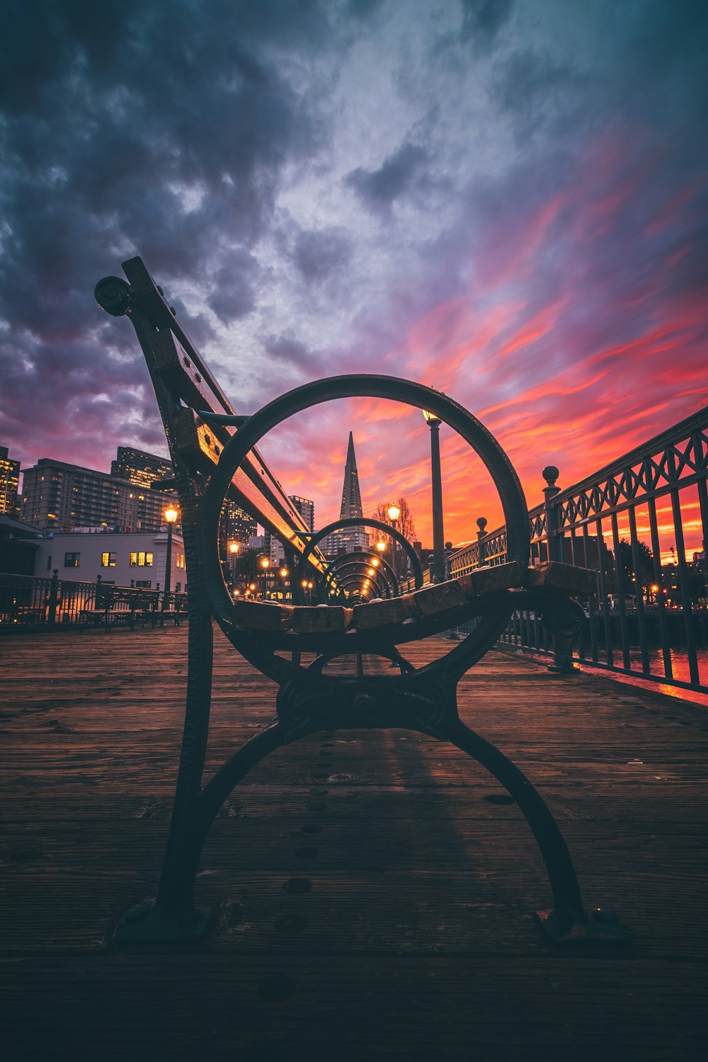 a bench sitting on top of a wooden floor next to a river