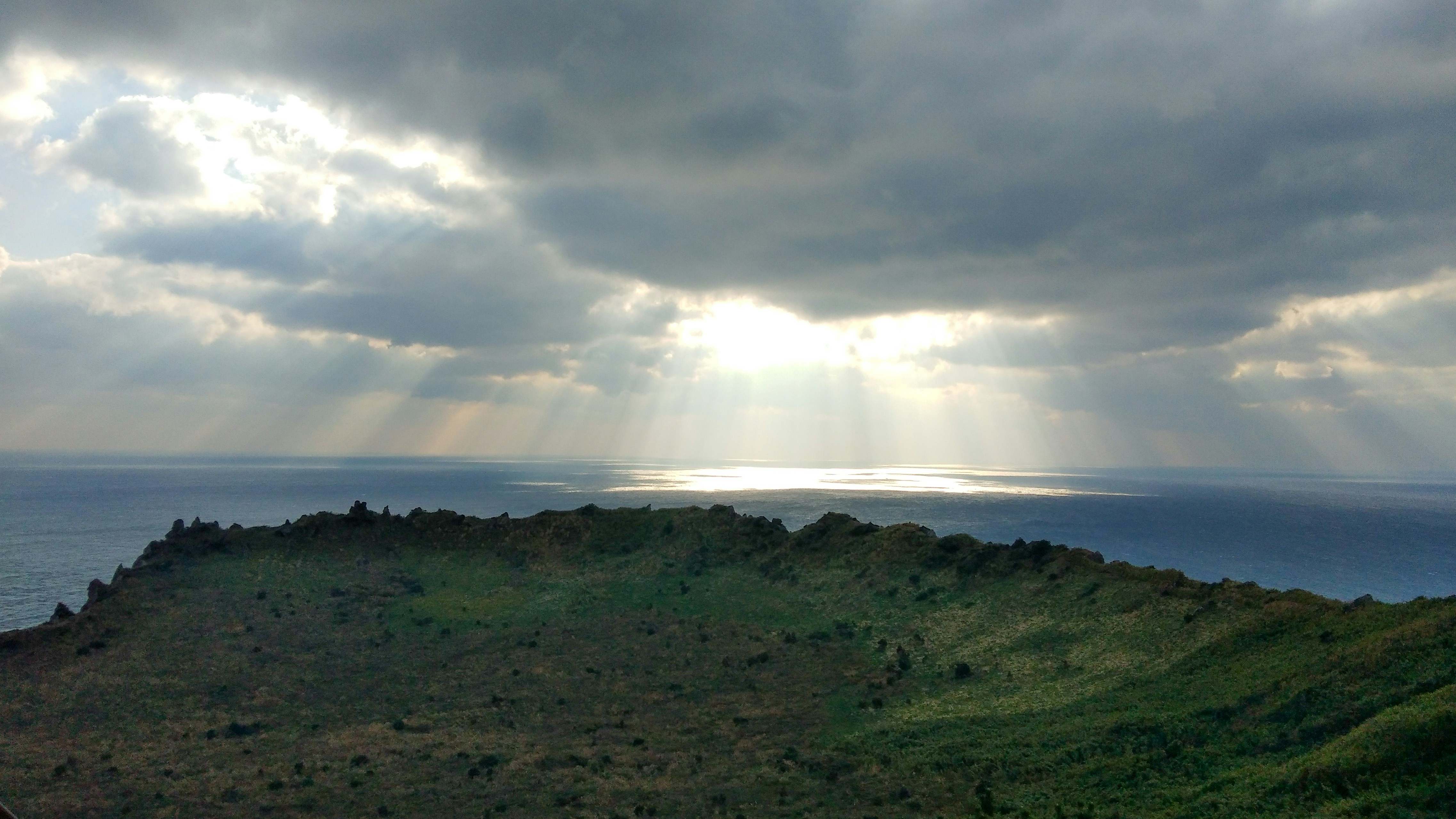 the sun shines through the clouds over the ocean