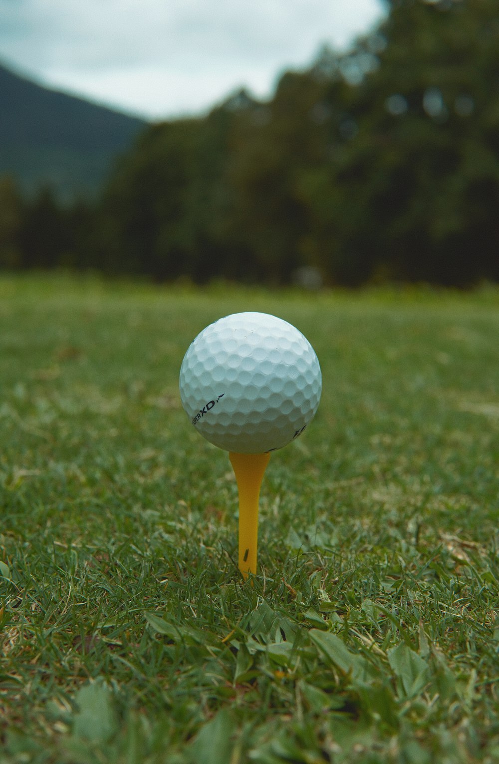 ein Golfball, der auf einem gelben Abschlag sitzt