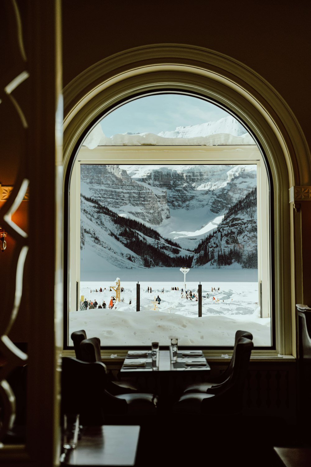 a view of a snowy mountain from a restaurant window