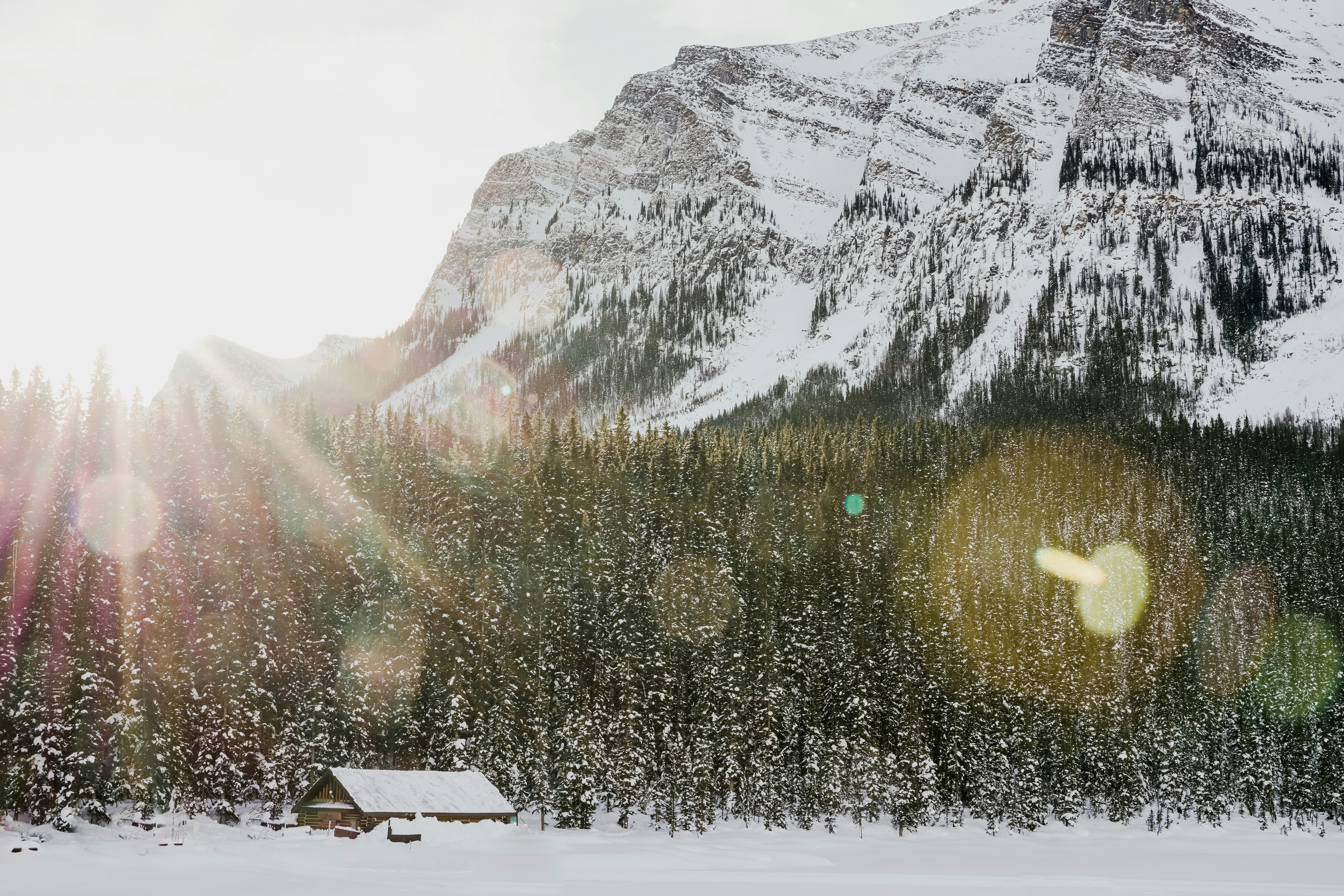 A snow covered mountain with a cabin in the foreground photo – Free ...