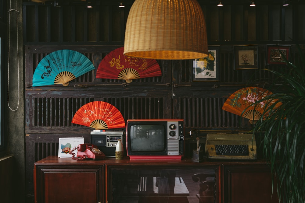 une chambre avec une télévision, un ventilateur et une lampe