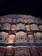a very tall building with many windows lit up at night