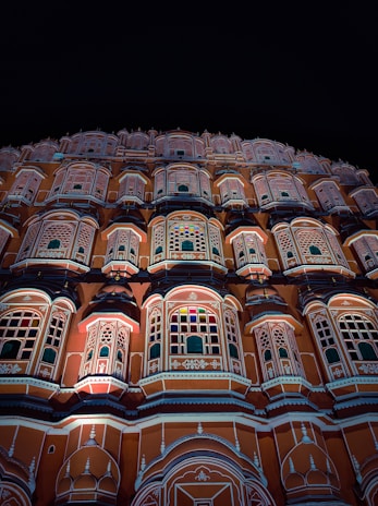 a very tall building with many windows lit up at night