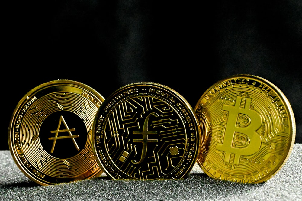 three gold bitcoins sitting next to each other