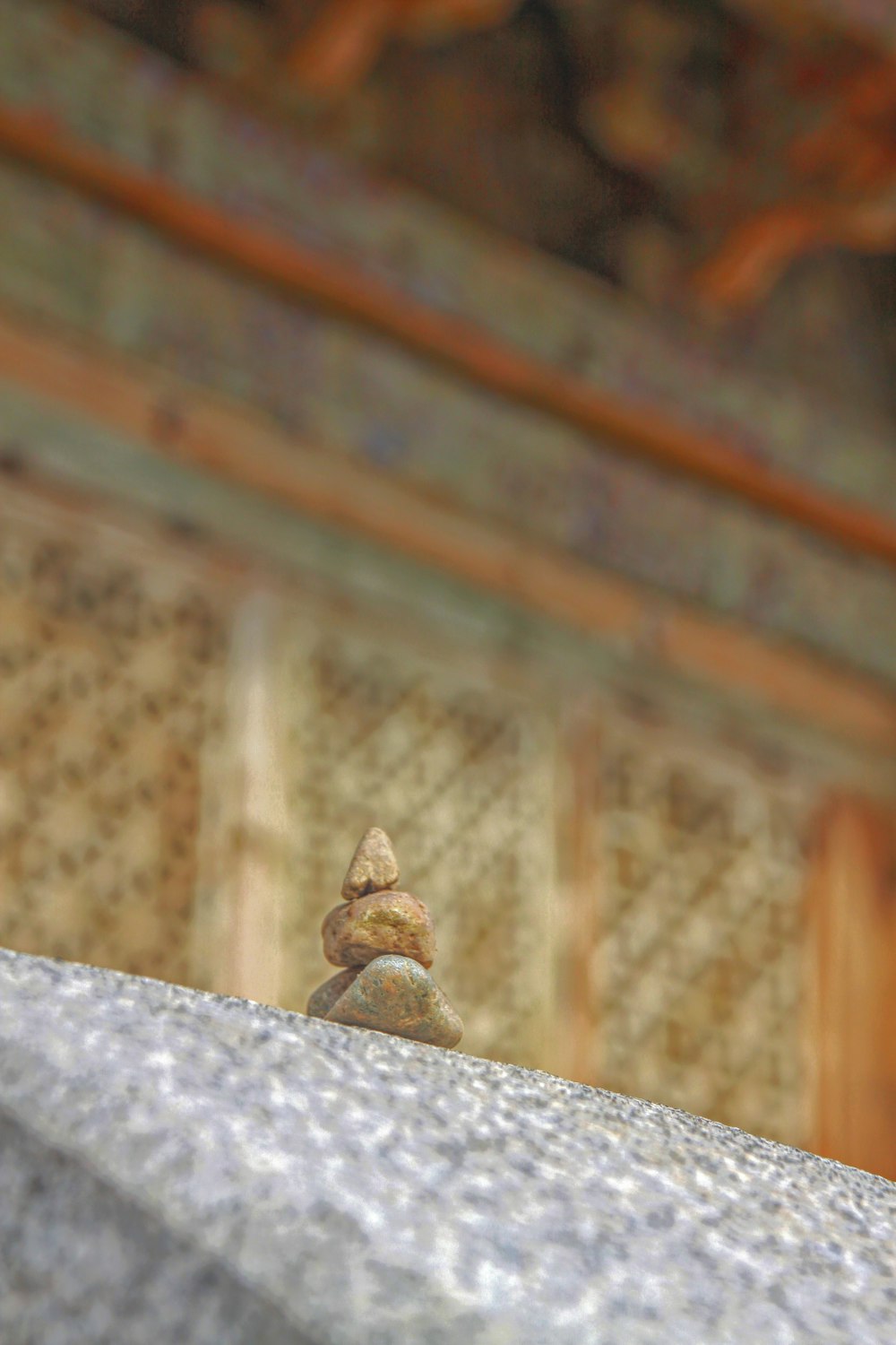 a small bird sitting on top of a stone wall