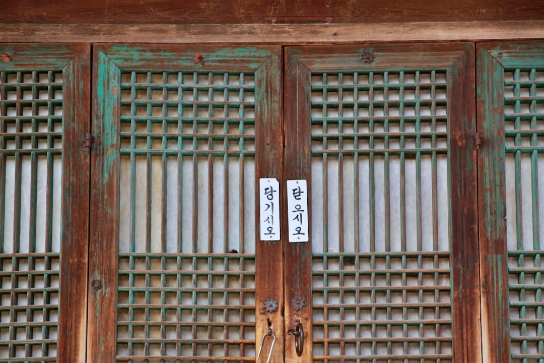 a pair of scissors sitting on top of a wooden door,