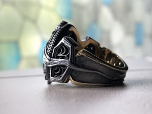 Close-up of a modern silver ring with intricate design on a dark background