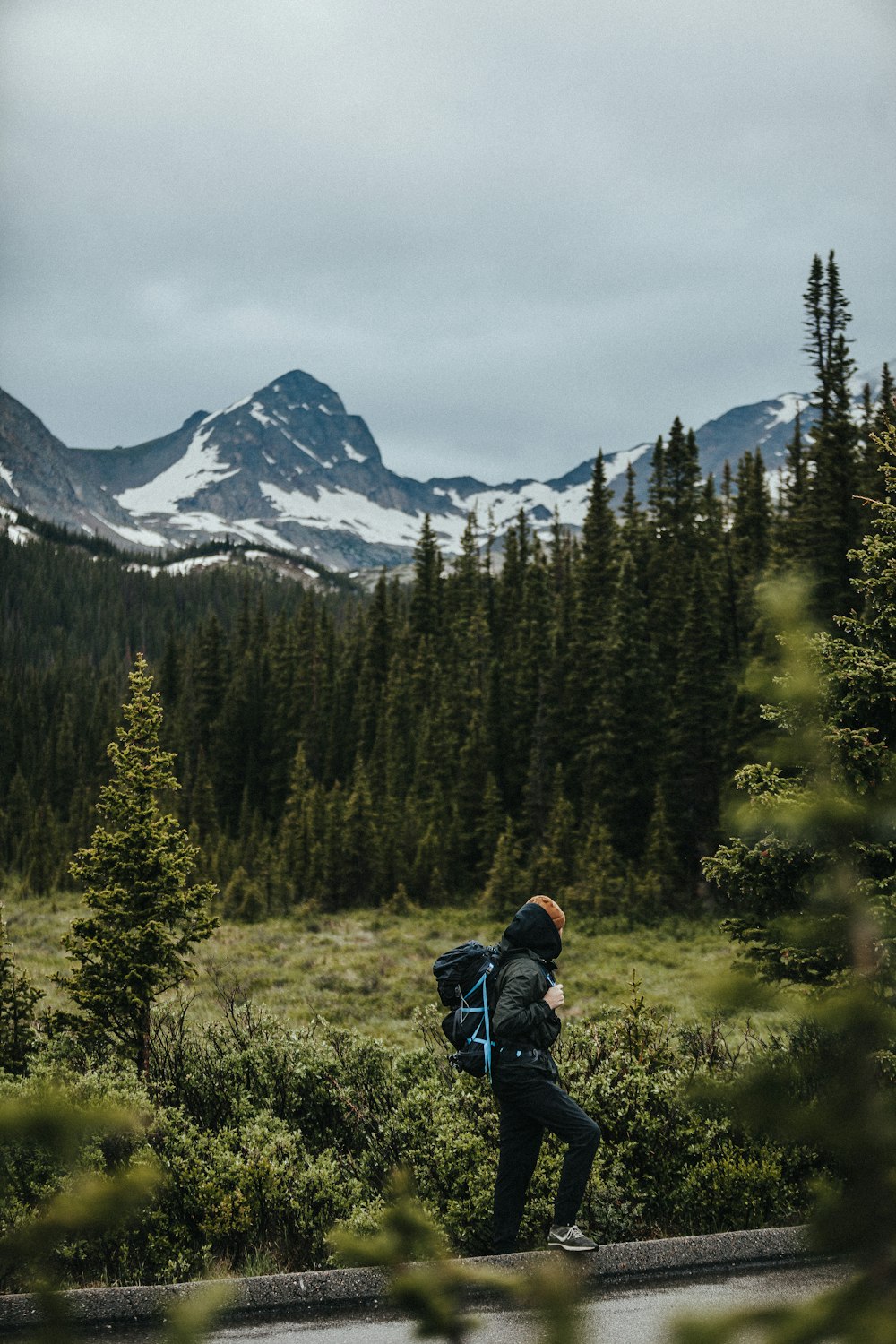 a man with a backpack walking through a forest