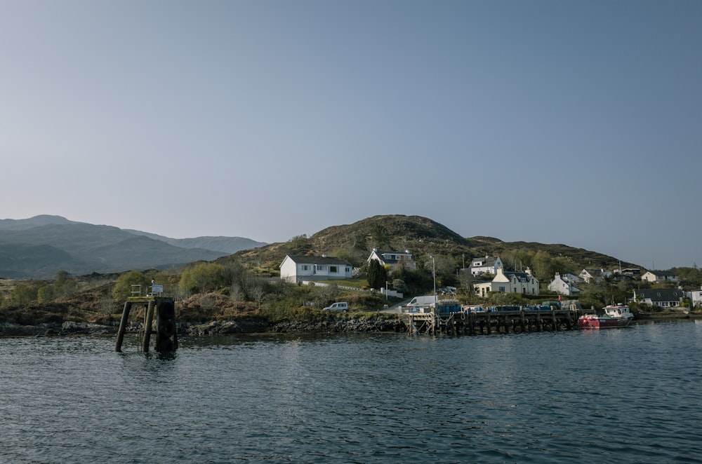 a body of water with houses on a hill in the background