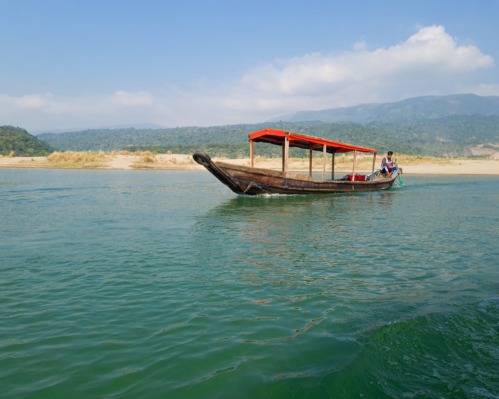 a long boat with two people on it in the water